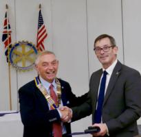 Gary Newton receives his Paul Harris Fellowship award from Club President George Paulson.