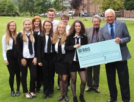 Paul Tebay receives cheque from outgoing Head Girl, showing a grand joint total of Â£500