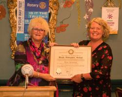 President Rhona presents club charter to new president Janice.