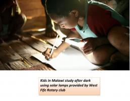 Children in Malawi study after dark using solar lights supplied by the Rotary Club of West Fife