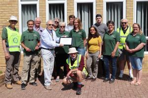 President Martin McGill (4th from left) presenting the Certificate of Appreciation to Dawn Woodgate from Seahaven Storehouse