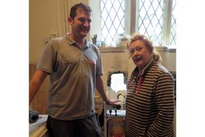 Tanat Heating plumber Jeremy Longhurst installing the new boiler for the Tanat Valley Theatre Group watched by Gaynor Richfield, joint founder of the group