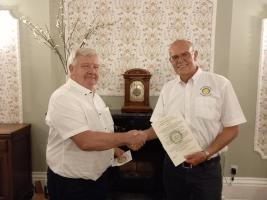Immediate Past President Mike Gicquel welcomes Mike Nairn as a member of the Rotary Club