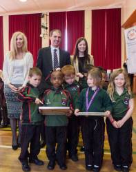 Staff and pupils with the certificate and accompanying illustration of the Shoebox Cycle.