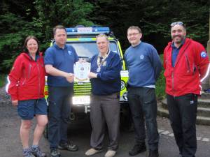 President John presents a banner to Bolton Mountain Rescue