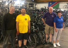 Rotarians Jackie Wellman and Bob Taylor with some of the helpers at Re~Cycle and some of the latest bike collection