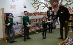 Rotarian Eric Skinner, accompanied by Head Teacher Nichola Bache, presents laptops to three enthusiastic pupils of Glebe Primary School 