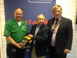 Last Year's President Barry Smith with Community Chair John Watson present the defibrillator.