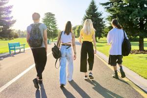 Four teenagers walking into sunset