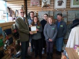 Mike Gicquel presents trophy to manager Naomi Moore and staff