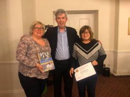 Claire and Sharon accept a Paul Harris Fellowship on behalf of their father.