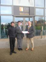 Cheltenham Rotary President Simon Wheeler presenting a cheque to an All Saints student. 