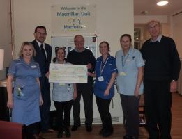 Brian Wilson from Macmillan Caring Locally receives the cheque from Rtn. Brian Clarke in the company of Macmillan nurses and Rtn. Richard Reader