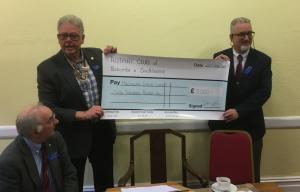 Rtn Neal Williams, Secretary to the Trustees, accepts a cheque  for £3000 from President David Shires