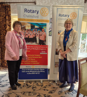 Two ladies standing in front of pull-up Rotary banners