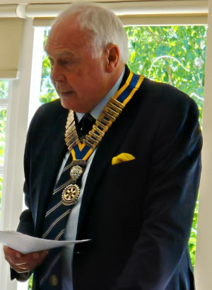 A white-haired man wearing a chain of office