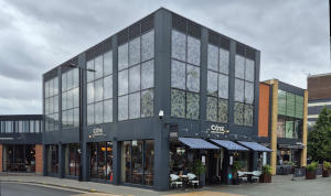 A dark grey cubic building with large windows