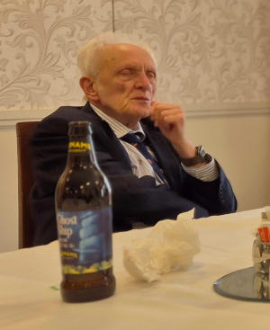 White-haired gentleman sitting at a dining table