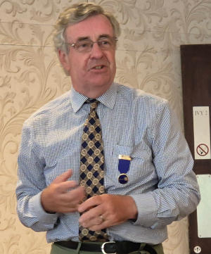 A shirt-sleeved gentleman wearing a Past President's jewell