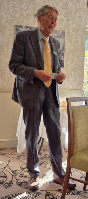 A tall man standing by a dining table