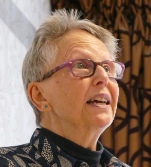 A woman with short grey hair wearing glasses