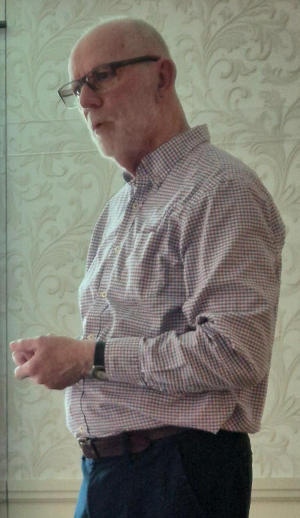 A gentleman in his shirtsleeves with glasses and a white beard and hair