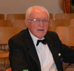 A white-haired man wearing a dinner suit