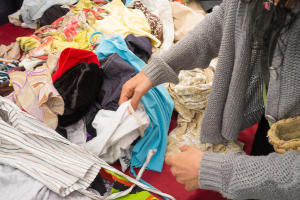Hands of a woman sorting through woolen items