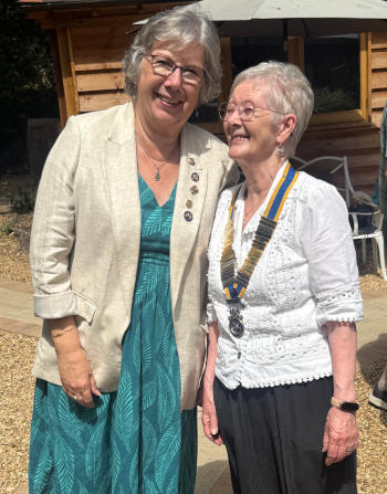 Two informally dressed women with silver hair, the one on the right of the picture wearing a Rotary chain of office
