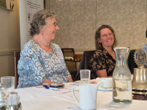 Two smiling ladies at a dining table