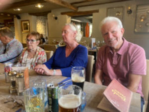 Smiling people on one side of a long dining table