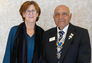 A woman with brown hair alongside a man wearing a chain of office