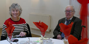 A grey-haired couple sitting at a dining table