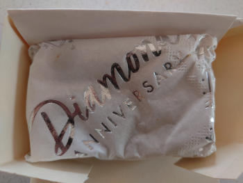 White wrapping bearing the words 'Diamond Anniversary' in a white box