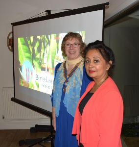 Two ladies standing in front of a projection screen