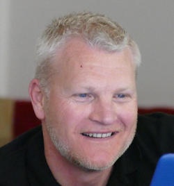 A smiling white-haired bearded man