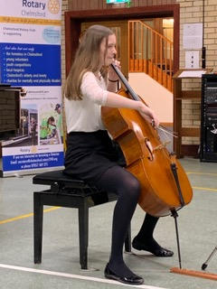 A long-haired young woman playing a cello