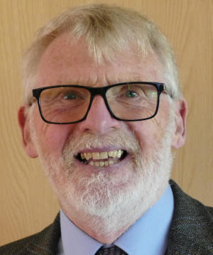 A smiling bearded man with glasses