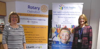 Two ladies standing either side of a Rotary pop-up banner and a Kids Inspire one