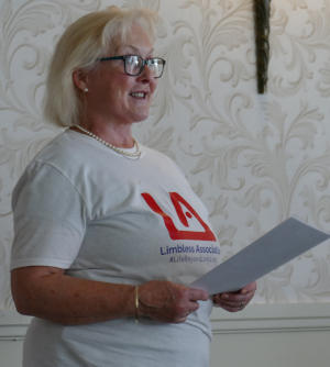 A woman with blonde hair and glasses wearing a Limbless Association T-shirt