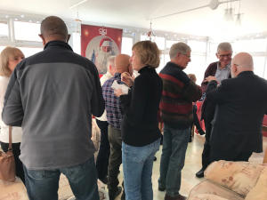 A crowd of people indoors holding cardboard cups