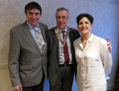 Two men, one wearing a Rotary chain of office, and a woman