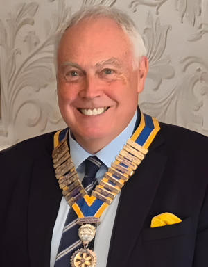 Smiling man wearing a President's chain of office