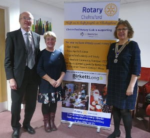 Two ladies standing either side of a Rotary banner, with a gentleman on the left