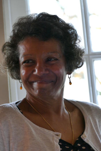 A smiling dark-skinned lady with curly hair