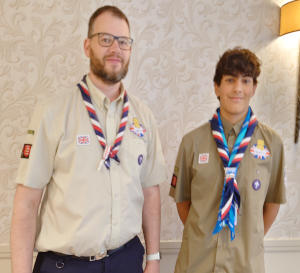 A bearded man and a teenage lad, both in Scout uniform