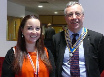 A young woman and a man wearing a chain of office