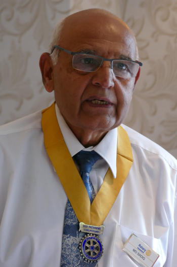 A bald man wearing a Rotary Vice-President's collar of office