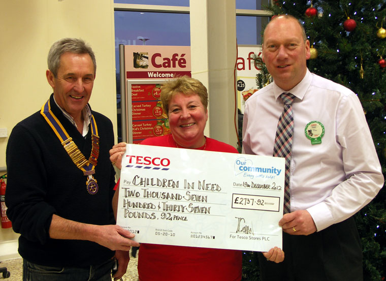 President-of-Southport-Links-Rotary-Club-John-Doyle-hands-over-the-cheque-for-money-raised-at-the-Children-in-Need-at-Tesco-Kew-Southport-2012