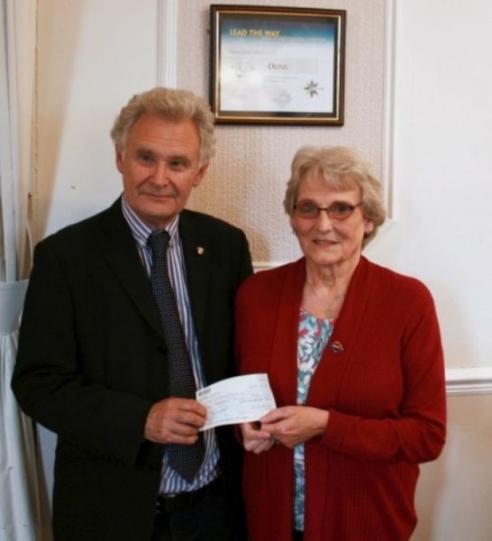 The club hands over a cheque for a thousand pounds to May Longmuir,